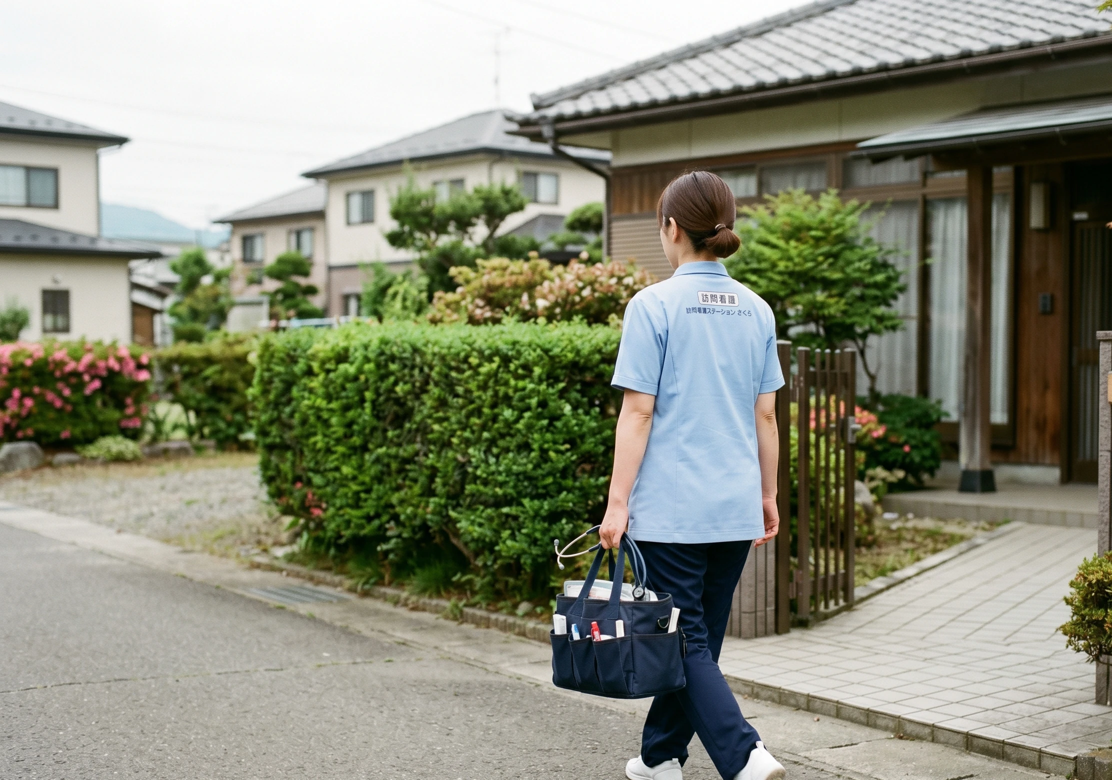 訪問看護師が地域の住宅街で訪問先に向かうシーン